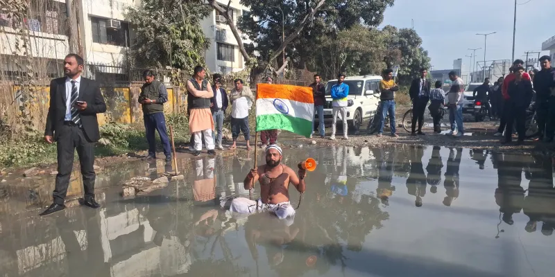 मुज़फ्फरनगर में टूटी सड़क के लिए घंटों गंदे पानी में बैठा युवक, मचा हंगामा तो जागे मंत्री और चेयरमैन, दिया आश्वासन